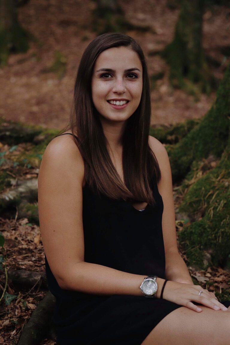 Caroline Mertz en robe noire, assise au pied d’un arbre (2018)