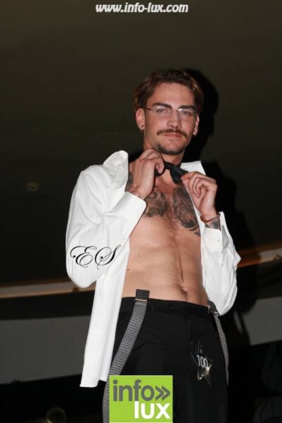 Marc Roger, Mister Tattoo Luxembourg 2019, en chemise blanche ouverte, sur scène
