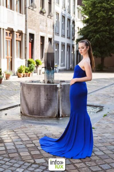 Gwendoline Gouverneur en robe longue bleue, près d’une fontaine