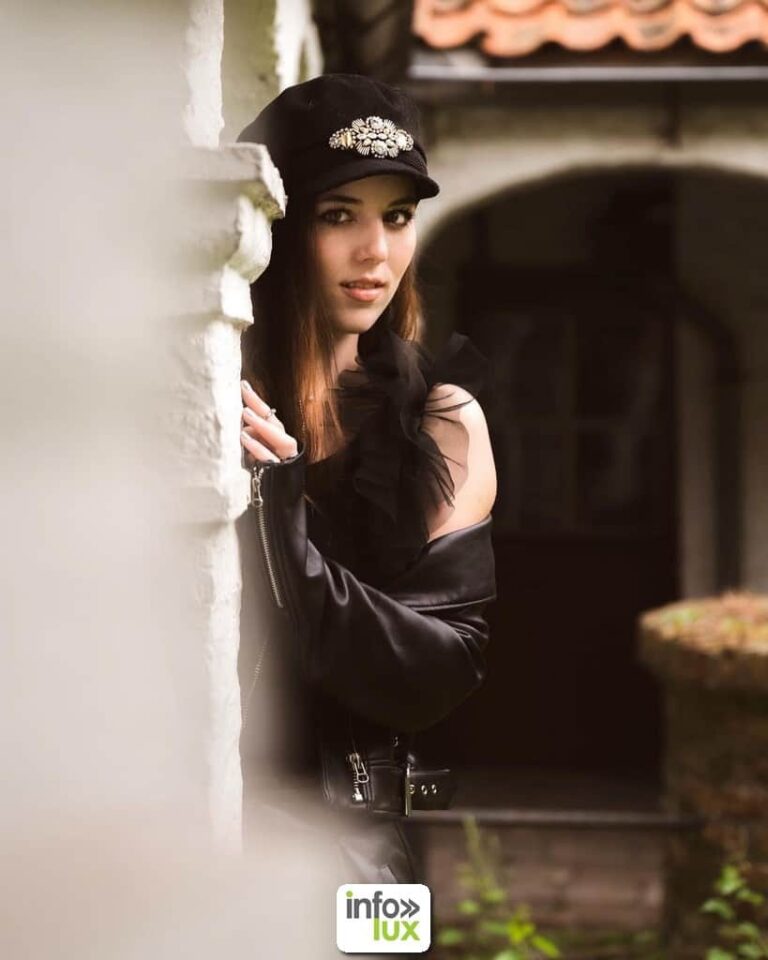Gwendoline Gouverneur en casquette et veste de cuir, sous un porche