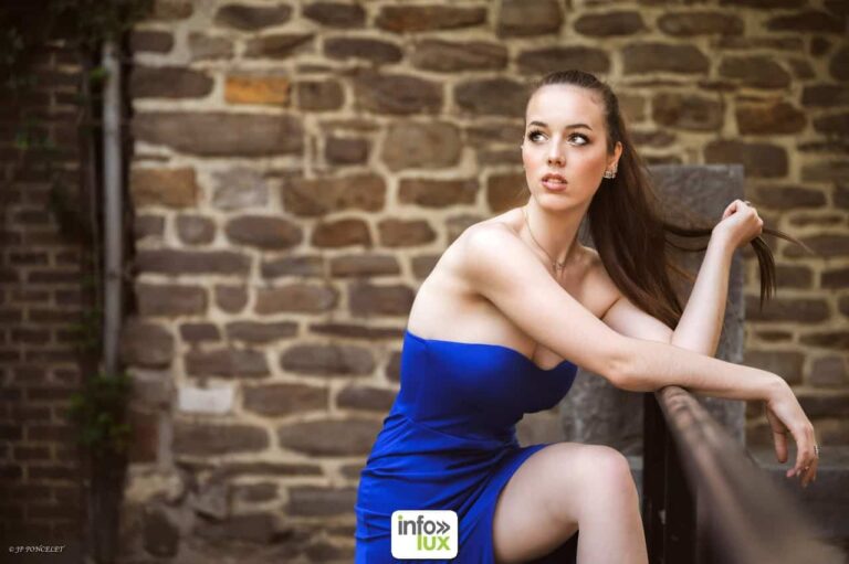 Gwendoline Gouverneur en robe bleue, devant un mur de pierre