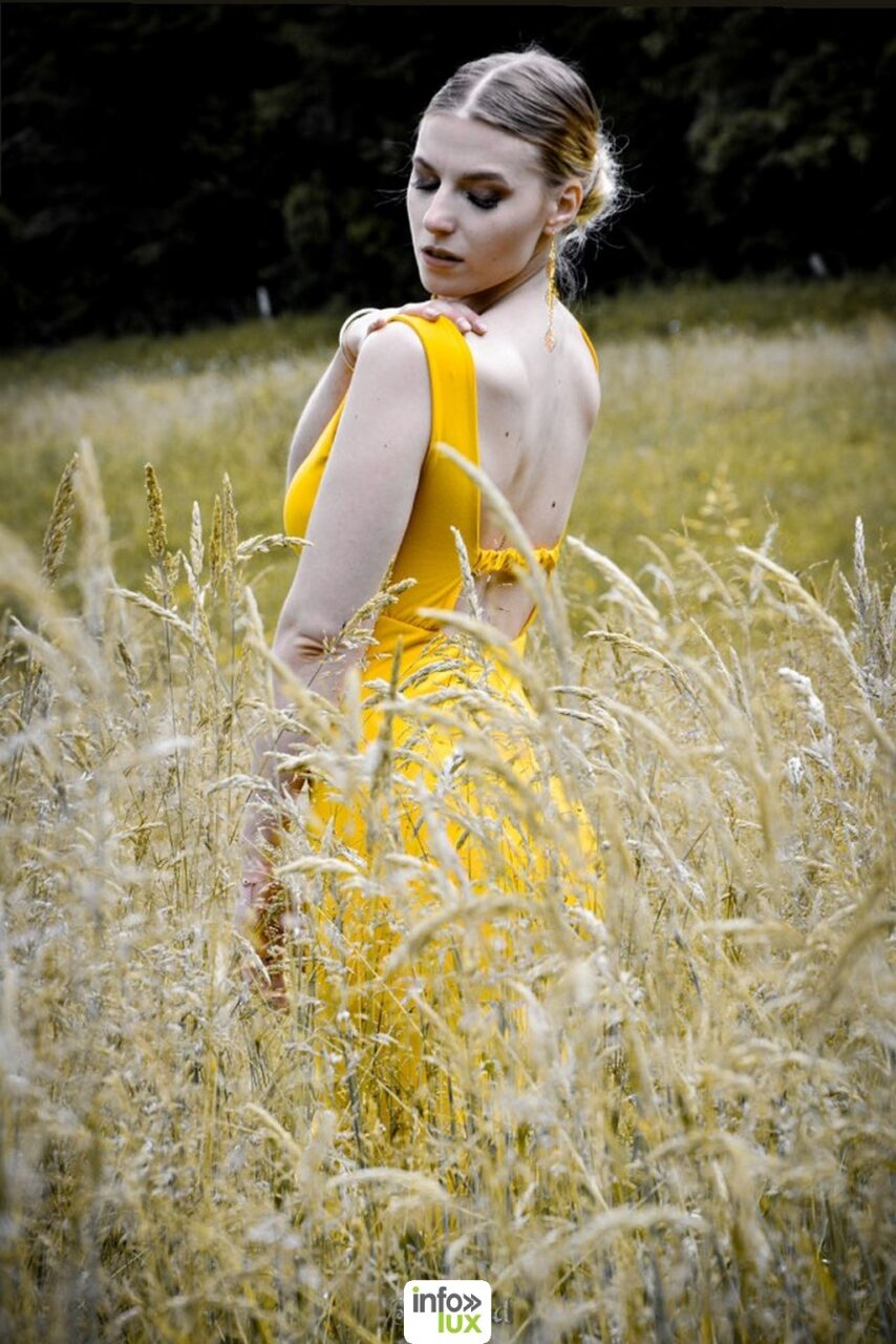 Claudia Stella en robe jaune, dans les hautes herbes