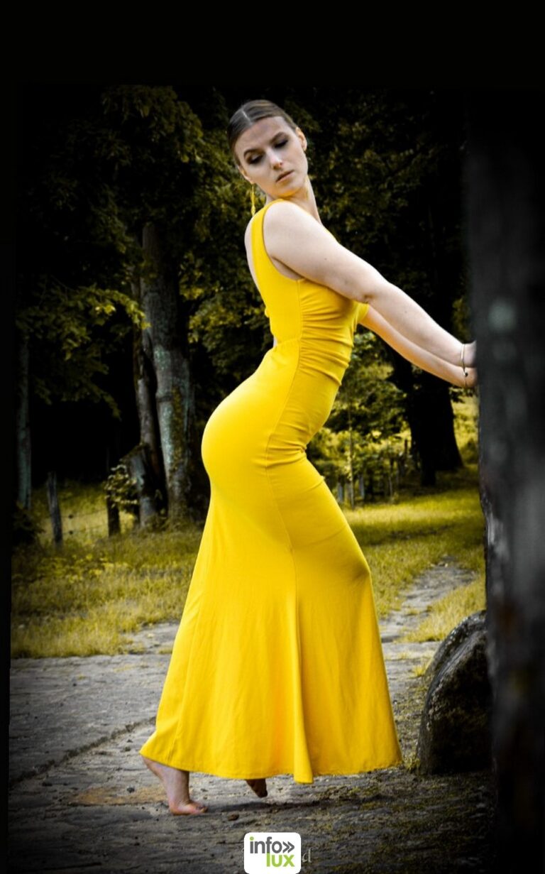 Claudia Stella en robe longue jaune, en lisière de forêt