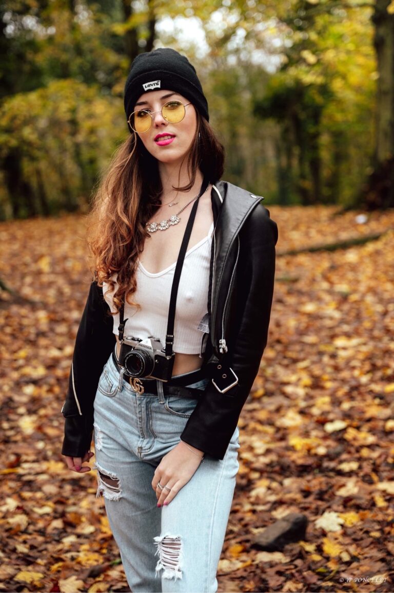 Gwendoline Gouverneur en bonnet et appareil photo, dans les feuilles d’automne