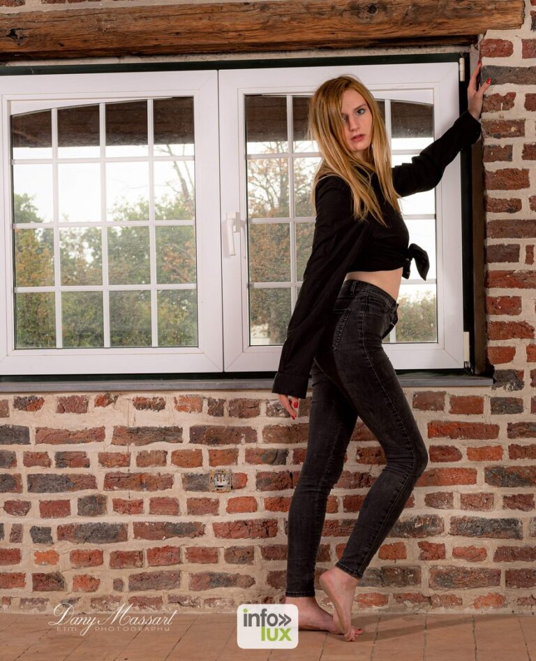 Laura Vervekken en noir et jean, devant une fenêtre