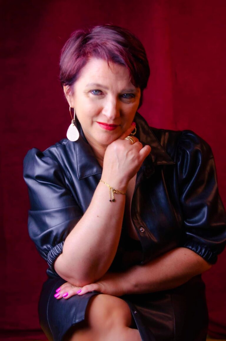 Véronique en robe de cuir noir, assise, en studio