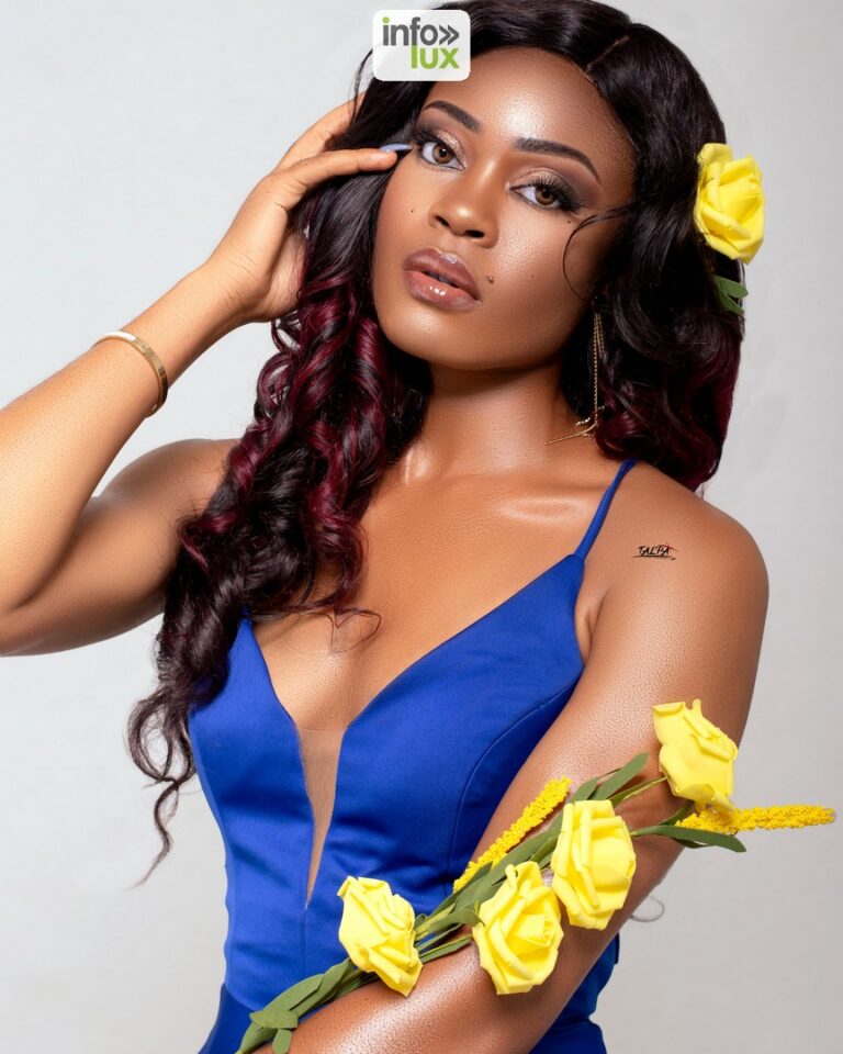 Maeva Righetti en robe bleu roi, une fleur jaune dans les cheveux