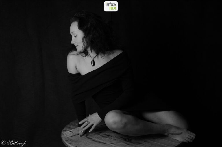 Marysa assise sur un tabouret de bois, en noir et blanc