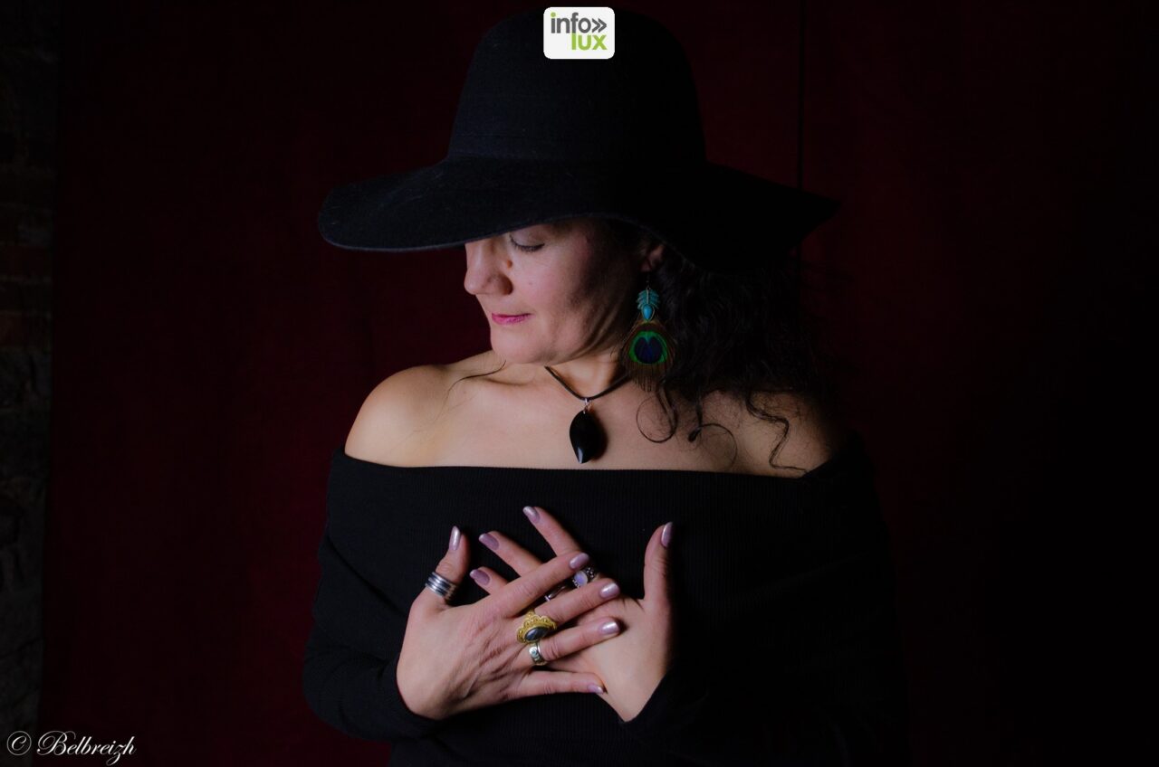 Marysa en chapeau noir, les mains croisées