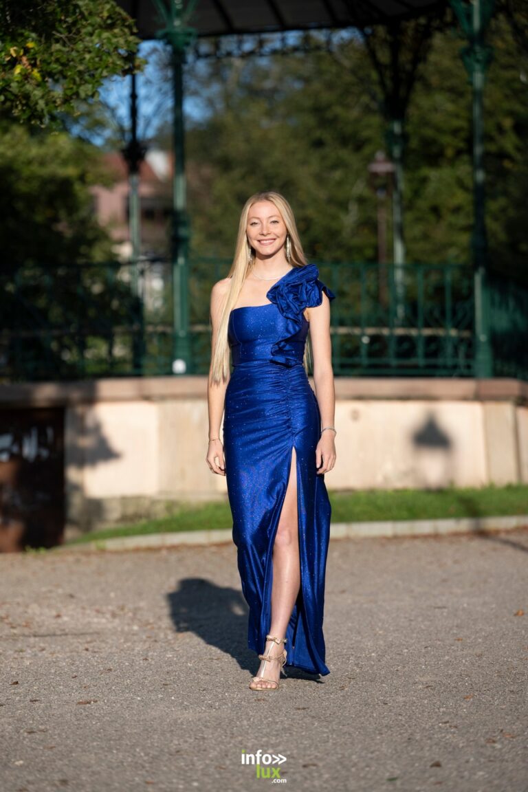 Margot Grivel en pied, robe bleue, devant un kiosque