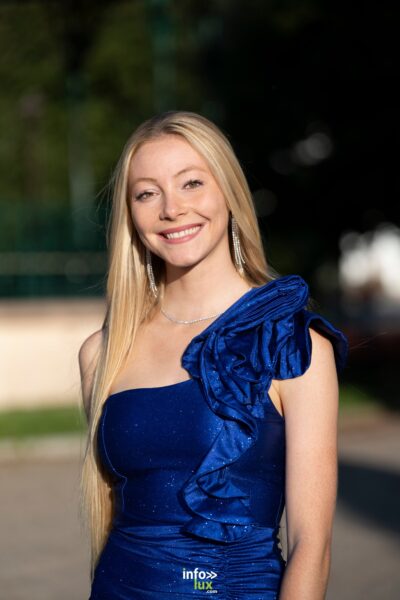 Margot Grivel en robe bleue à volant, sourire au soleil