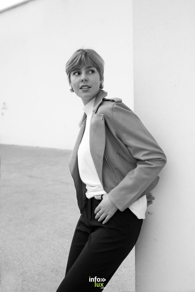 Anaïs Arnould Mousty en veste de cuir, adossée à un mur blanc, en noir et blanc
