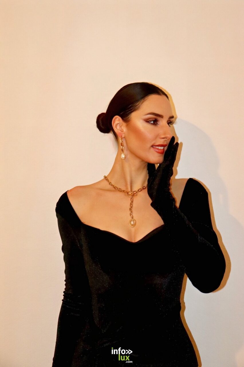 Émilie Barchetta en robe noire et gants longs, sur fond clair