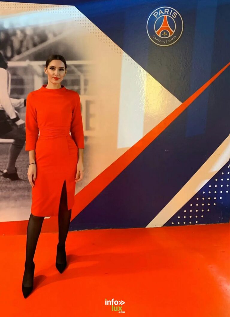 Émilie Barchetta en robe rouge, devant un décor aux couleurs du Paris Saint-Germain