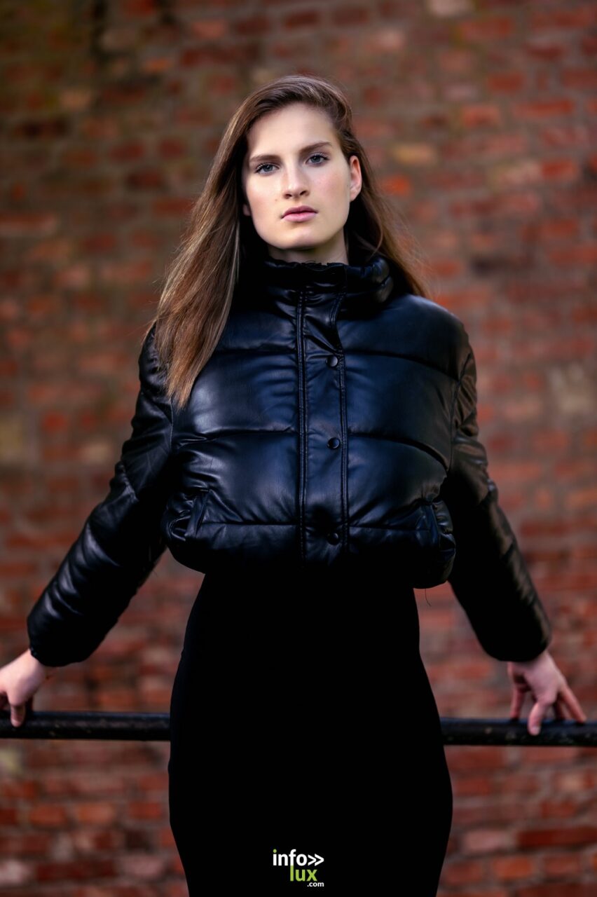 Léanne Stéphano en doudoune noire, devant un mur de briques