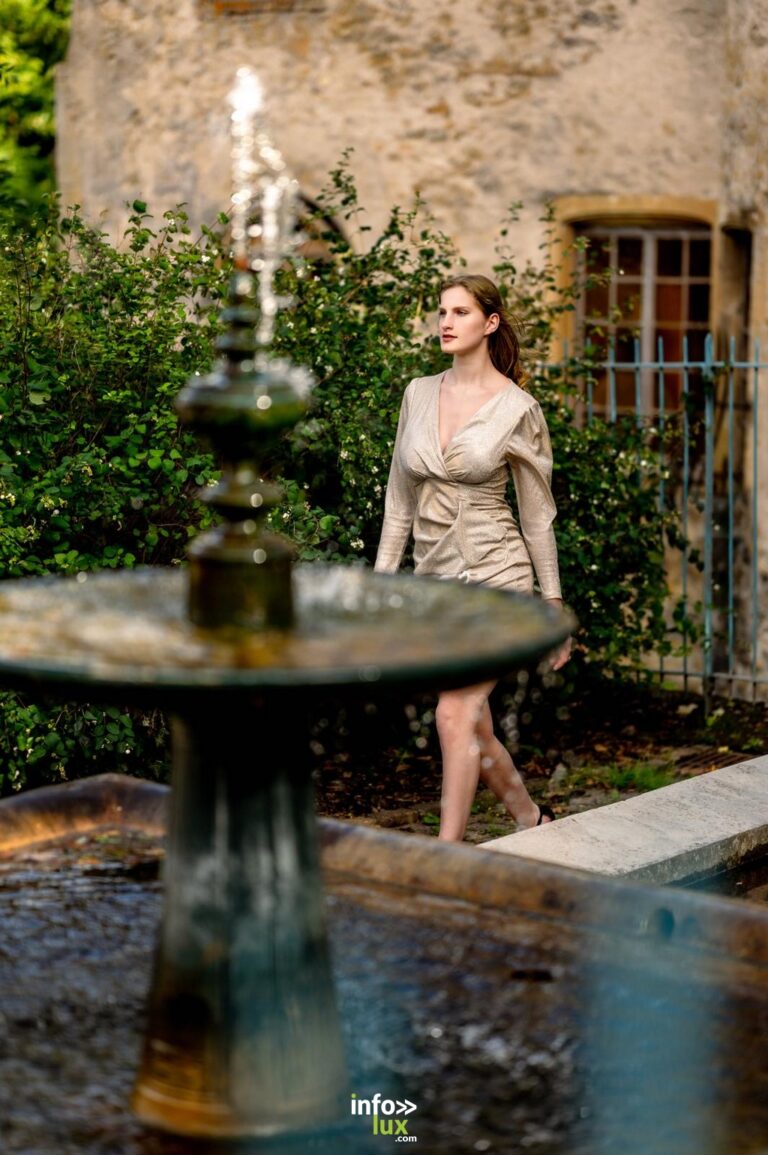 Léanne Stéphano en robe beige, derrière une fontaine