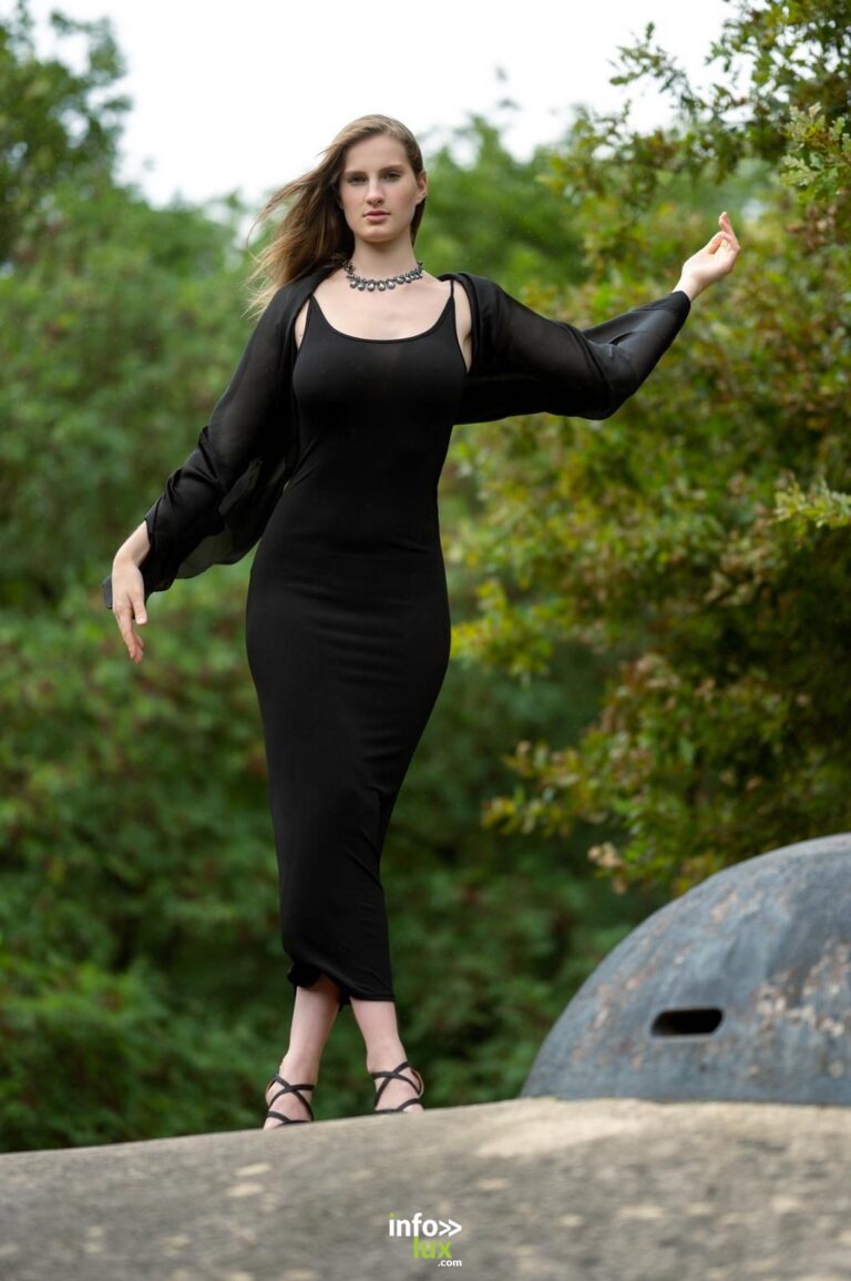 Léanne Stéphano en robe noire, bras tendu, dans la verdure