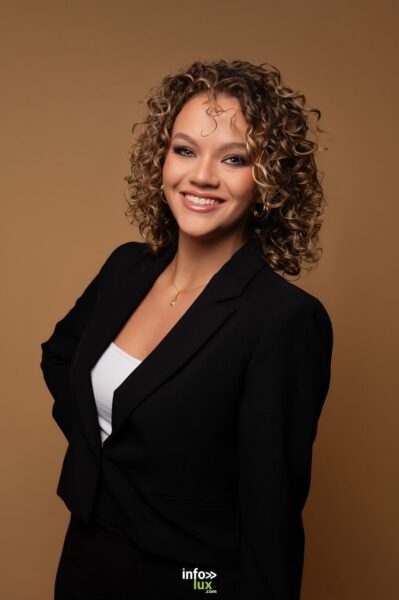 Marine Herbé en blazer noir, sourire aux lèvres, en studio