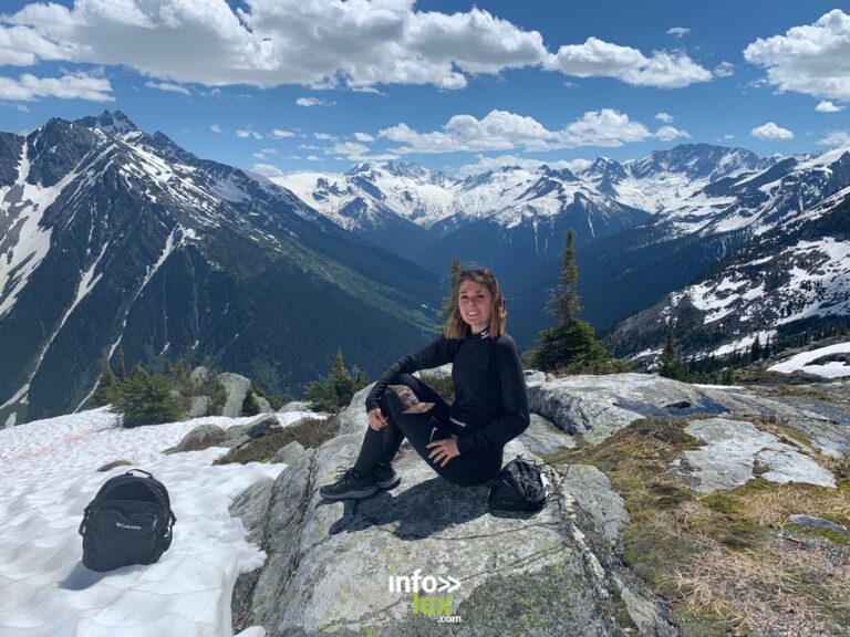 Valentine Jacques assise sur un rocher, face aux montagnes enneigées