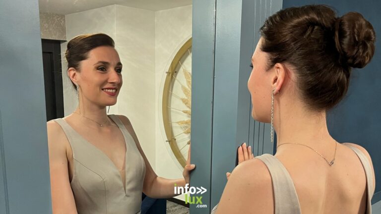 Valentine Jacques en robe beige, cheveux en chignon, face à un miroir