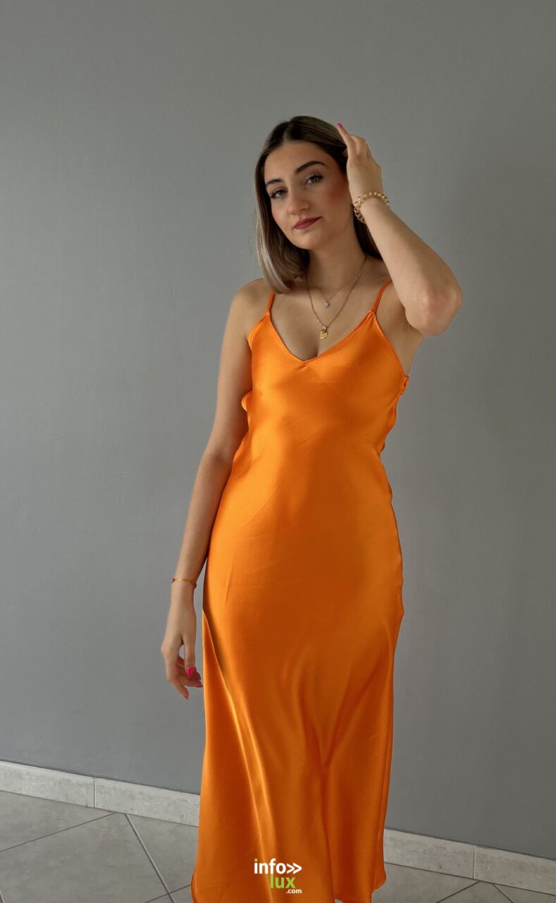 Carla Mastrorillo en robe longue orange satinée