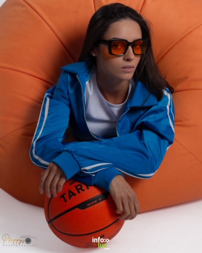 Cécile Ponzellini en survêtement bleu et lunettes orangées, un ballon de basket entre les bras