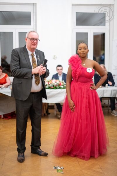Stacy Byll-Cataria, badge n° 7, en robe fuchsia, face au présentateur lors de l’élection, à Nilvange