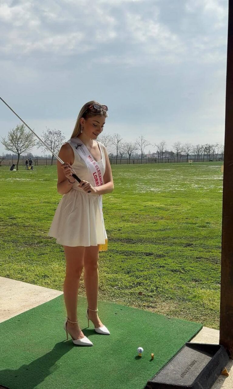 Carla Mastrorillo en robe blanche, club de golf en main