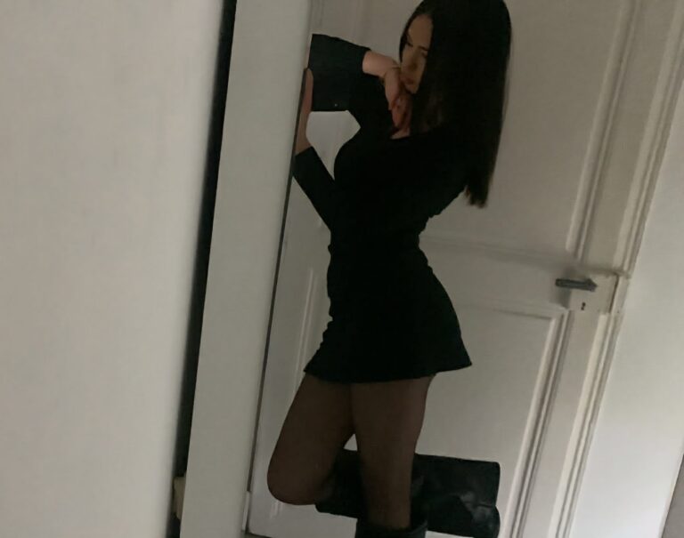 Léonie Schwab en petite robe noire, contre une porte