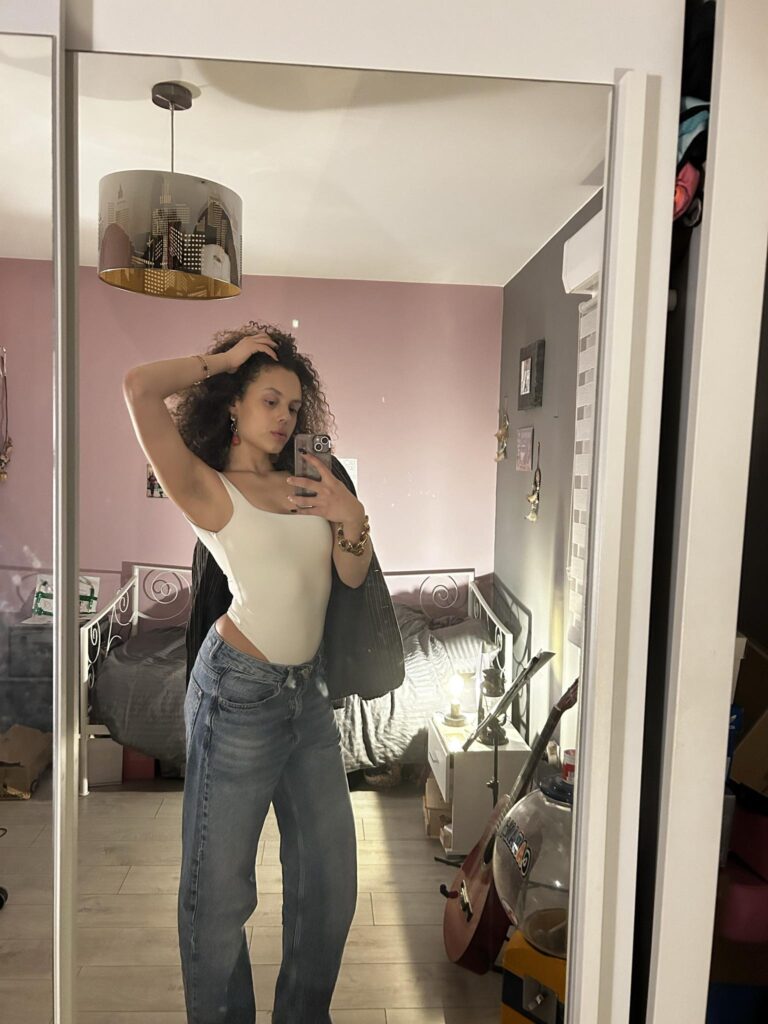 Louna Dos Santos, body blanc et jean, devant un miroir