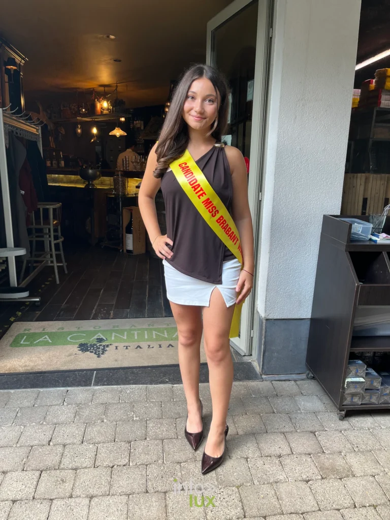 Eléa Colasuonno, écharpe de candidate, devant l’entrée d’un restaurant (été 2026)