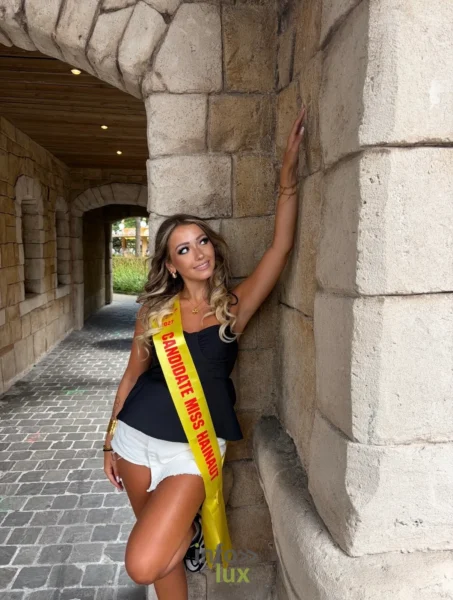 Isaline Dubois, écharpe de candidate Miss Hainaut, sous une arcade de pierre (été 2026)