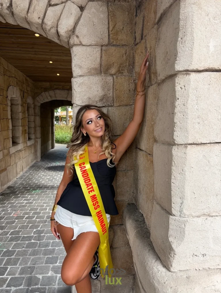 Isaline Dubois, écharpe de candidate Miss Hainaut, sous une arcade de pierre (été 2026)