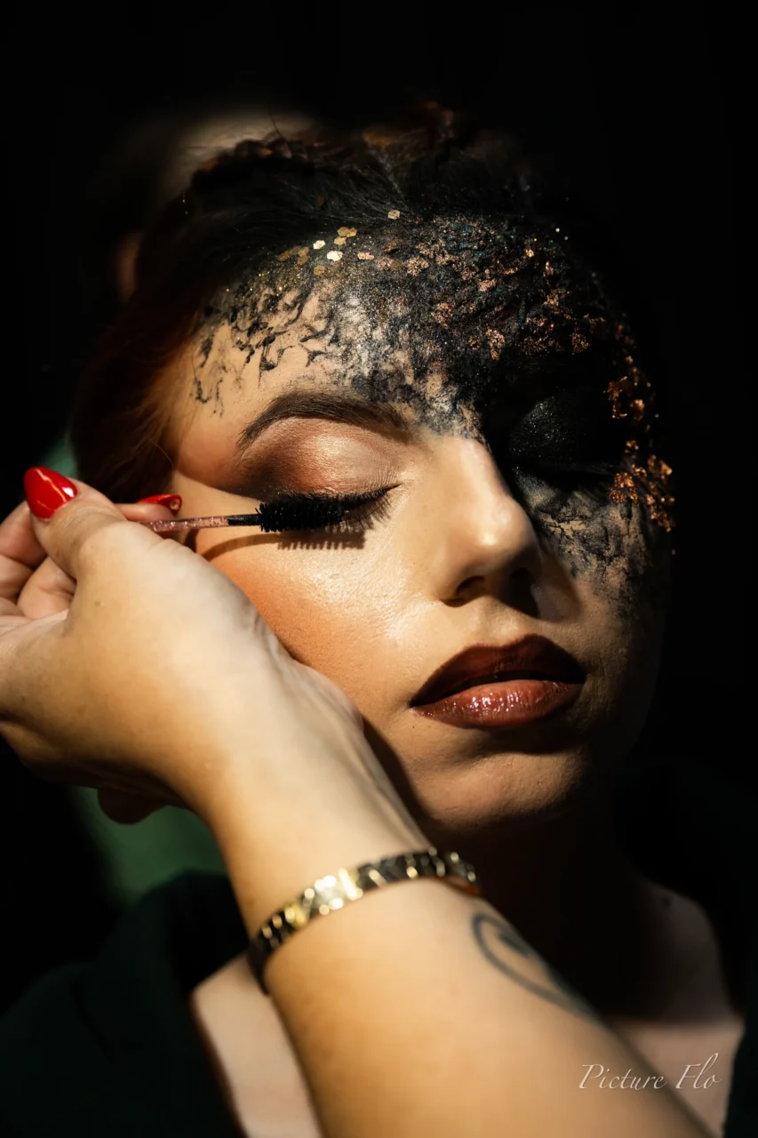 Pose du mascara ; la pâte noire couvre déjà le front