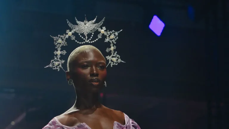 Robe-corset à imprimé mauve fermée par des agrafes métalliques, manches bouffantes, auréole en filigrane argenté — Alimac, « Mystic Blossom », Lux Fashion Week 2026, Arlon