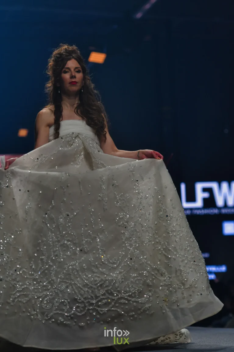 Elfenbeinfarbenes, mit Pailletten besticktes Ballkleid, der Rock mit beiden Händen gerafft, Kollektion „Le Fil Sacré“