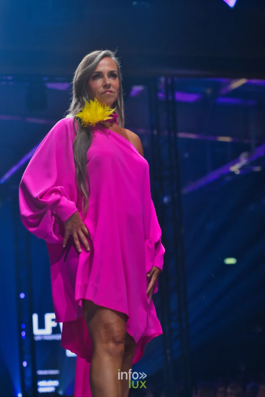 Robe fuchsia asymétrique à une épaule et manche ample, fleur de plumes jaunes, collection « Meraki bloom » d’Hélène Guiot