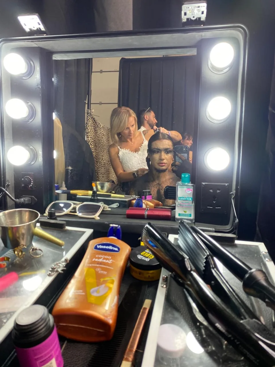Dans le miroir des coulisses, pendant la coiffure, la première étape de sa journée